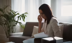 a woman sitting on top of a couch holding a cell phone
