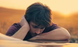 a man holds his head with both hands
