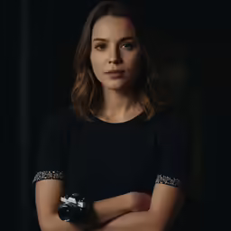 a woman wearing black and posing for a picture