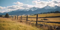 a long wooden fence stretches out towards the mountains