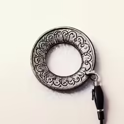 a metal key chain with a charm that looks like an old chain