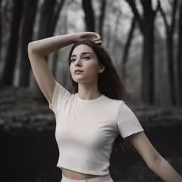 a beautiful young woman standing in front of trees