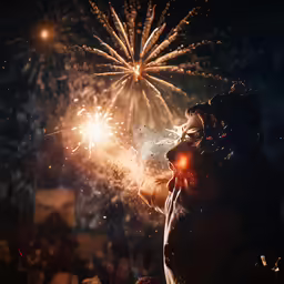 a woman holding a small sparkler up in the air