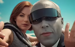 a man and woman pose for a selfie in front of the ocean