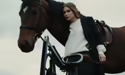 a woman standing in front of a horse