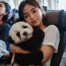 the young woman is holding a white dog