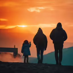 a family looks out at the view as the sun sets