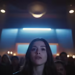 a woman standing in front of an audience looking off to her left