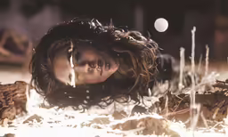 a woman laying in the snow with long hair