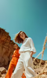 two women in orange jumpsuits and white shirts