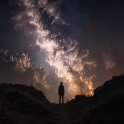 man standing in the dark with clouds of blue and yellow