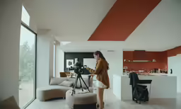 a woman using a tripod to film her living room