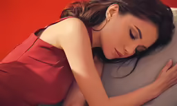 a woman is holding her back while sleeping