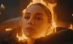 a woman sitting in front of a flame