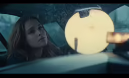 a girl looking out the window of a car in rainy weather