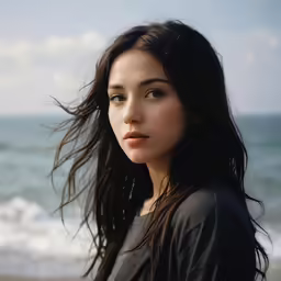 a woman standing in front of the ocean