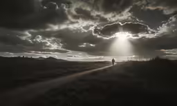 a man that is walking down a dirt road