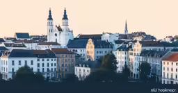 a city with many buildings and spires near trees