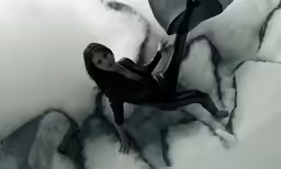 a young girl leaning over an ice wall holding an umbrella
