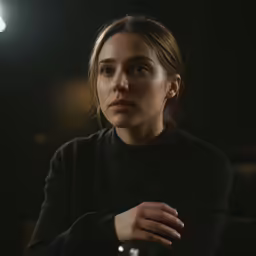 woman sitting in the darkness staring