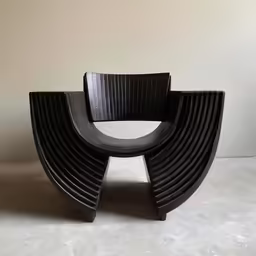 the curved chair is made from black wood