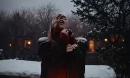 the woman is standing outside on the snow covered ground