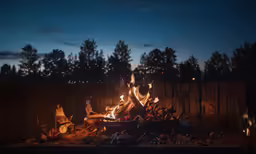 a fire pit outside at night with many items on it