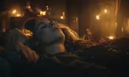 a woman sleeping in bed next to lights
