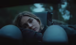 woman hiding behind her car seat with the light on