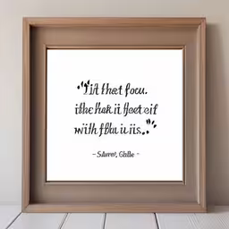a white framed photo that is on the wall,a white and black print of a quote in frame