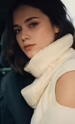 a girl sitting down and wearing a white scarf