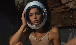 a woman in beige top sitting down in front of a mirror