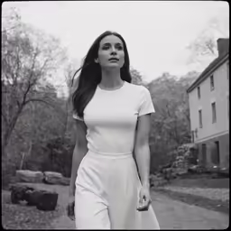 a young woman in white is walking down the street
