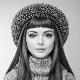 a girl with long dark hair wears a knit sweater and a hat