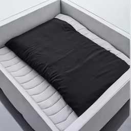 an angled position bed that has a cushion and a pillow for seating