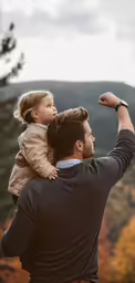 a father holding his son up to the sky