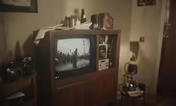 a tv sitting on top of a wooden shelf
