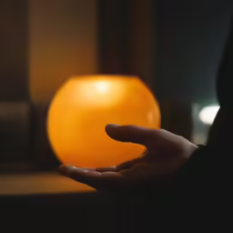 a person holding their hand over an orange ball