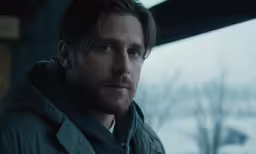 a man in jacket staring at the camera
