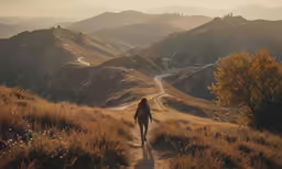 a person riding a bike down a dirt road near mountains