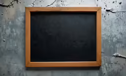 a blackboard mounted to a wall near a rusted wall