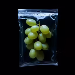 grapes are packaged in clear plastic bags and placed on a black background