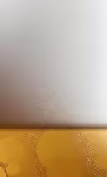 bubbles in a yellow glass are seen on a white surface