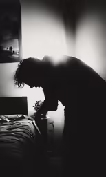 the shadow of the person in front of a bed