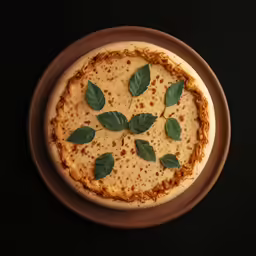 a white pizza with cheese and toppings with green leaves on it