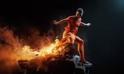 a young man in an orange shirt kicking a soccer ball