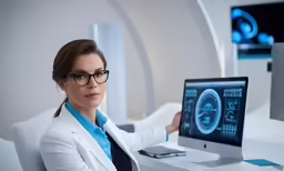 a female doctor with glasses and a laptop