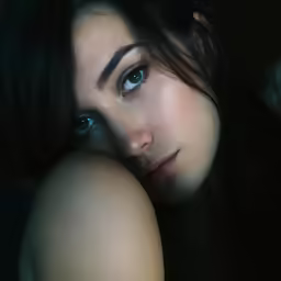 a beautiful woman leaning her head on a chair