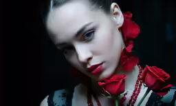 a woman with red roses around her neck