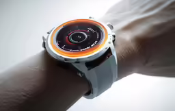 a person wearing an orange and white watch on his wrist